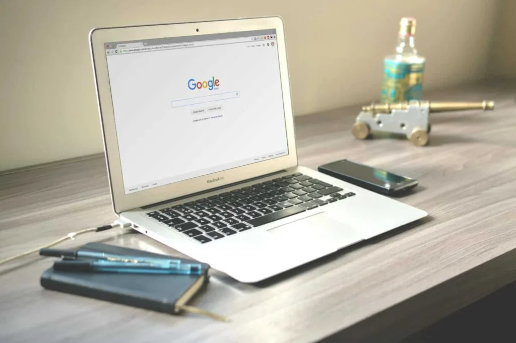 Laptop sur un bureau qui a un navigateur ouvert avec la page Google.