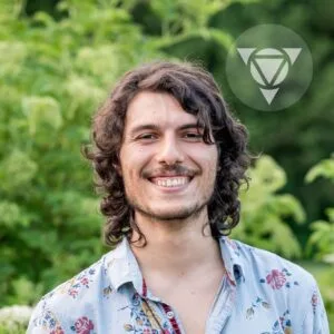 Photo de Xavier Harel, concepteur web, avec feuillage vert en arrière-plan.